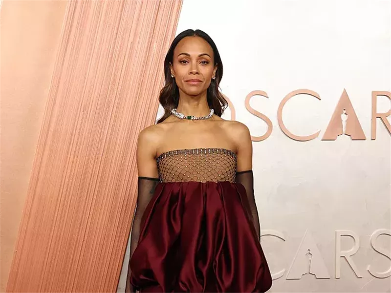 زوي سالدانا تتألق بفستان سان لوران بلون البرغندي في الأوسكار 2025